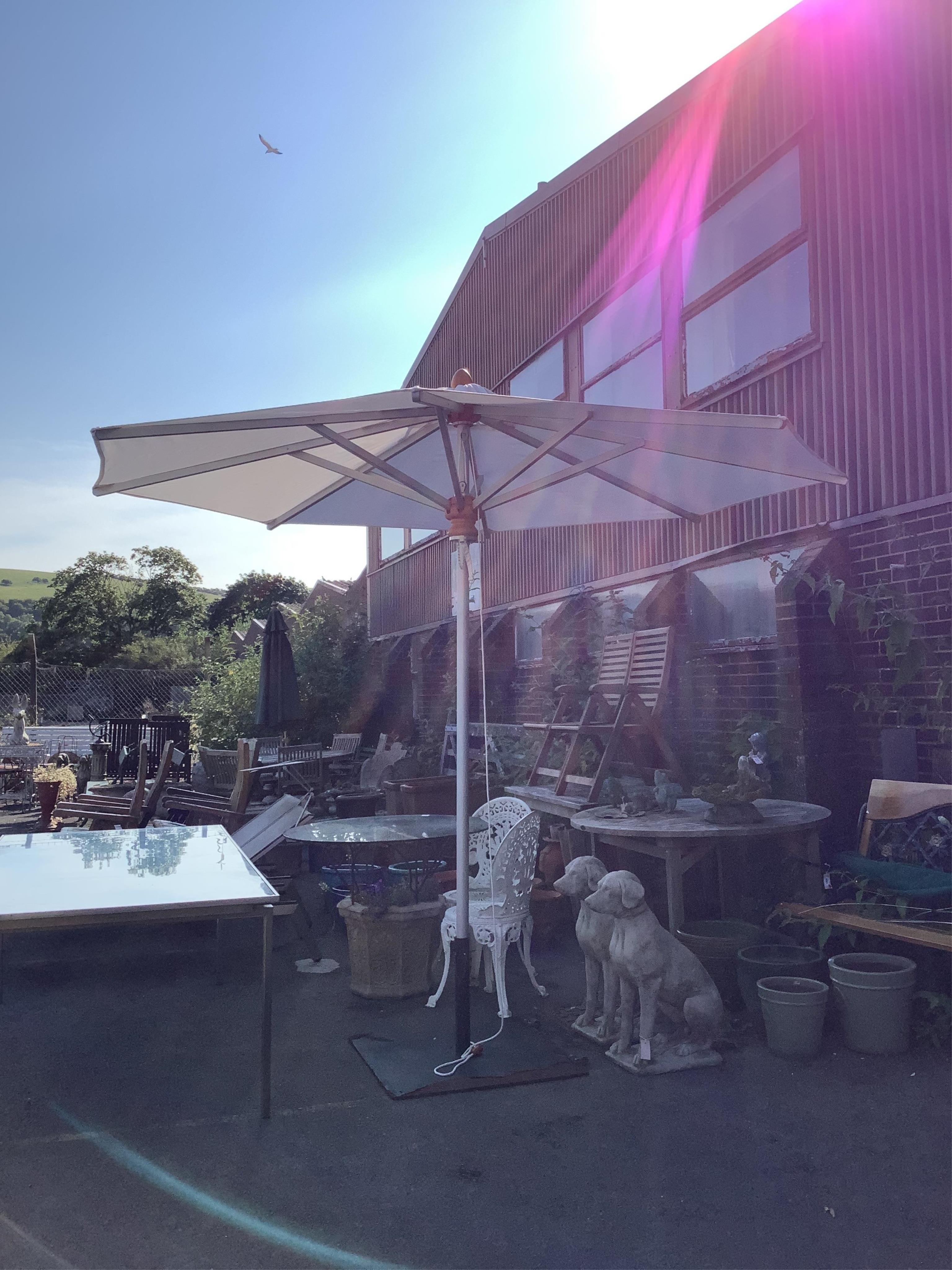 A Barlow Tyrie 10ft diameter white canvas garden parasol with cast iron base and canvas cover. Condition - parasol good, metal base fair